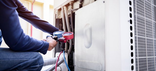 Technician checking air conditioner outside