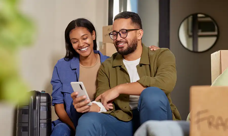 photo of a couple looking at a smartphone after moving